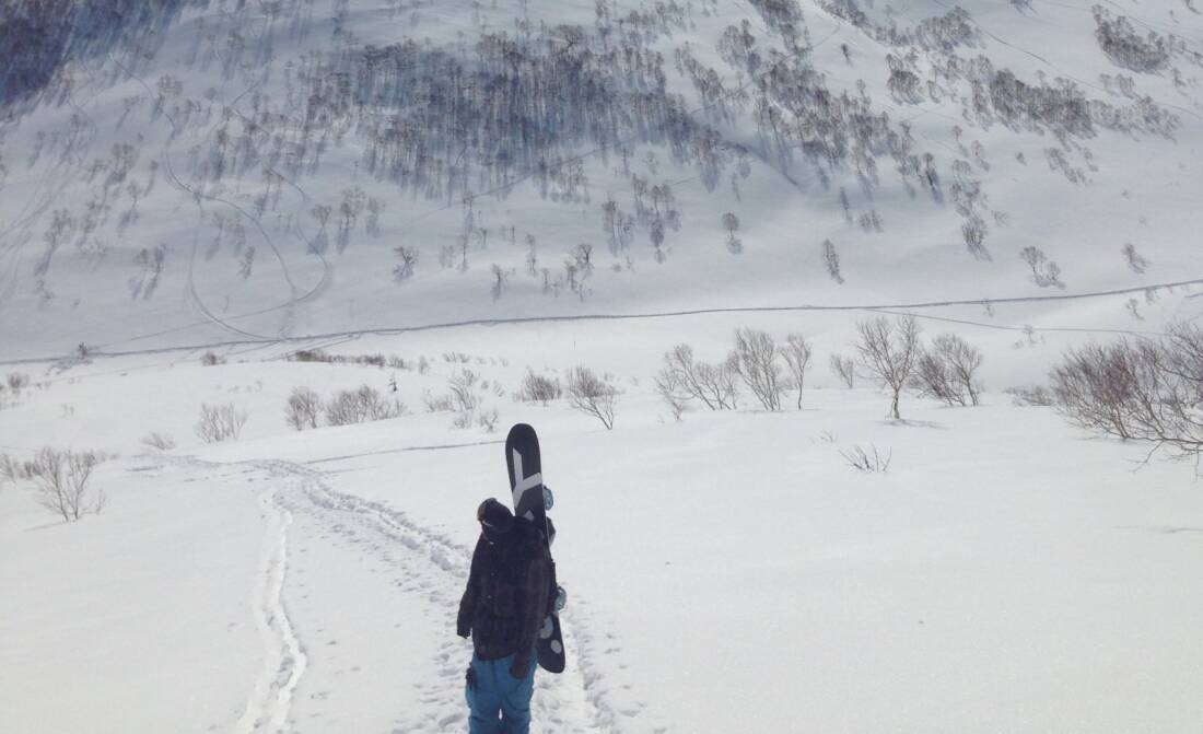 Snowboarder with powder board in the Niseko Backcountry