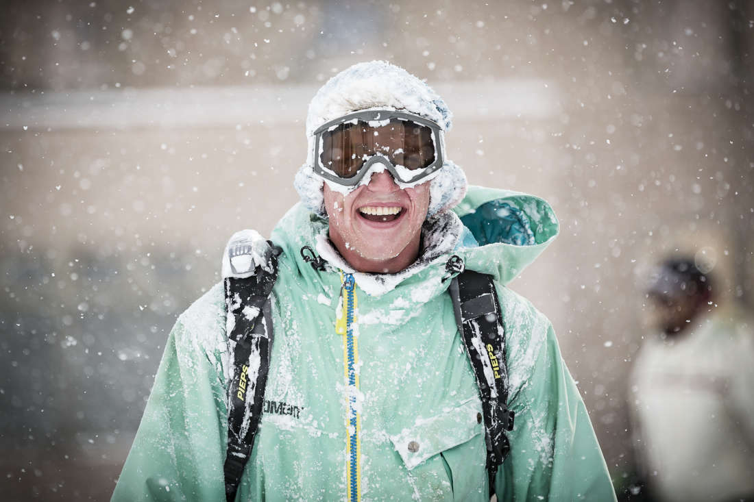 A happy snowboarder covered in powder snow in Niseko