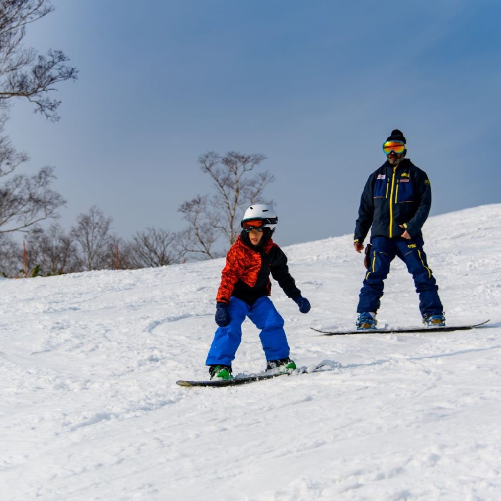 Instructor Adir during snowboard lesson with 7 year old
