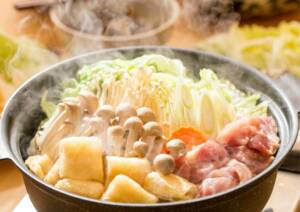 Japanese nabe hotpot with ingredients including mushrooms, meat and carrot