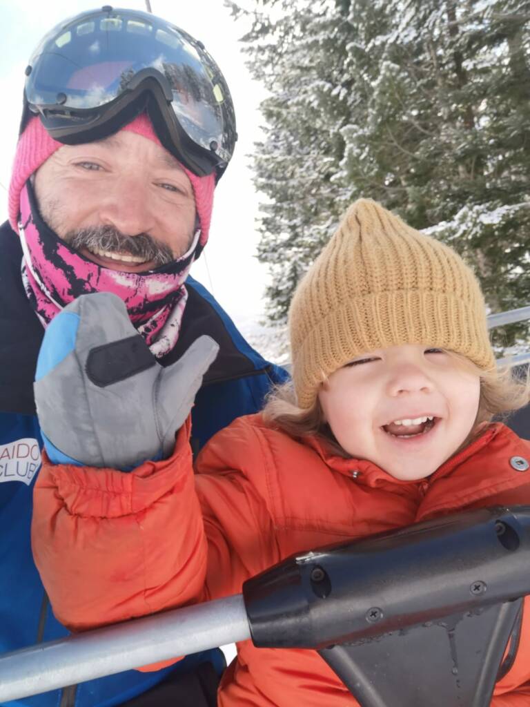 Kid smiling with instructor on chairlift